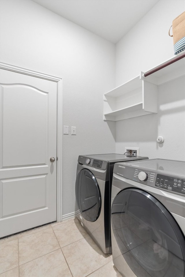 laundry room with washer and dryer and light tile patterned flooring