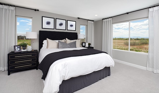 bedroom featuring light carpet and multiple windows