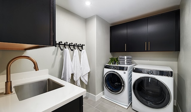 laundry area featuring sink, washing machine and dryer, cabinets, and light tile patterned flooring