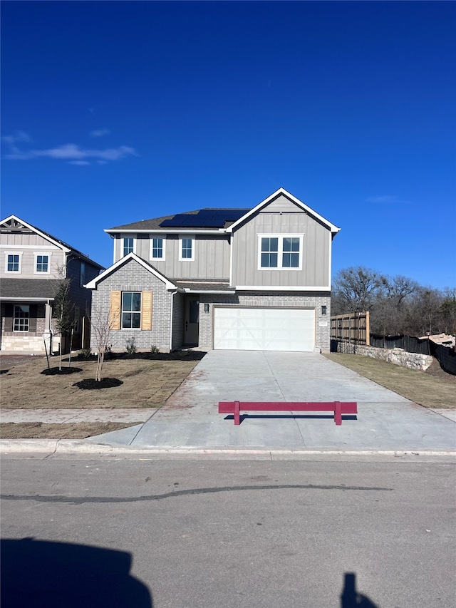 view of front of property with a garage and solar panels