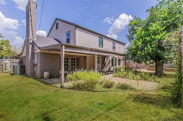 rear view of house featuring a patio, fence, a yard, french doors, and stairway