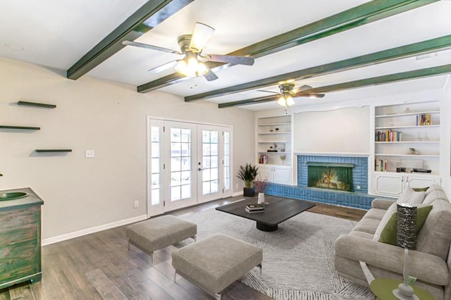 living room with a fireplace, wood finished floors, baseboards, french doors, and beam ceiling