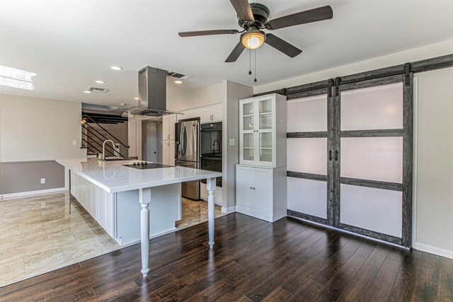 kitchen with black appliances, island exhaust hood, dark hardwood / wood-style flooring, white cabinetry, and a kitchen breakfast bar