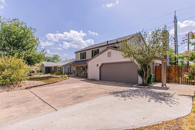 traditional home featuring driveway, an attached garage, and fence