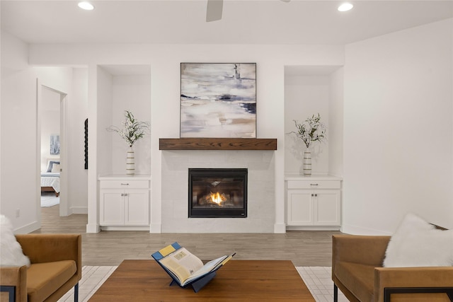 living room with light wood-type flooring and a tile fireplace