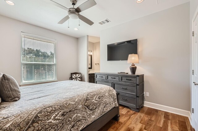 bedroom featuring ensuite bath, ceiling fan, and wood-type flooring