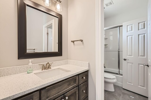 full bathroom featuring bath / shower combo with glass door, toilet, and vanity