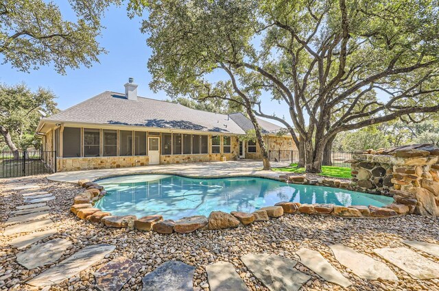 view of swimming pool with a patio area and a sunroom