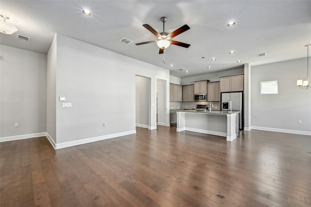 unfurnished living room featuring ceiling fan and dark hardwood / wood-style floors