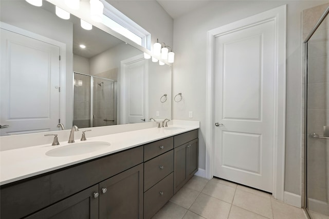 bathroom featuring a shower with door, tile patterned floors, and vanity