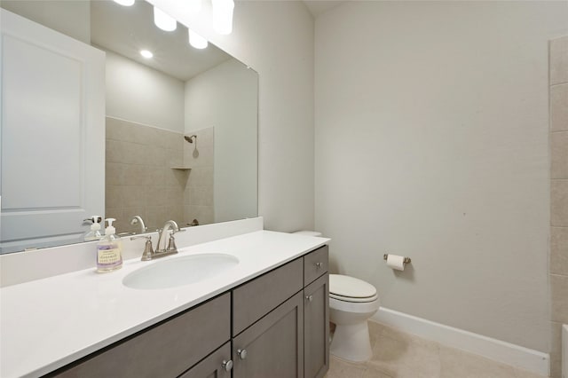 bathroom featuring tile patterned flooring, a tile shower, vanity, and toilet