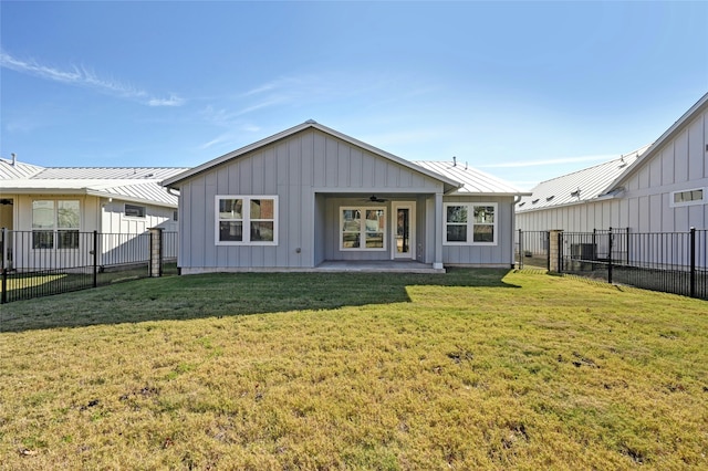 rear view of property with ceiling fan, a yard, and a patio area