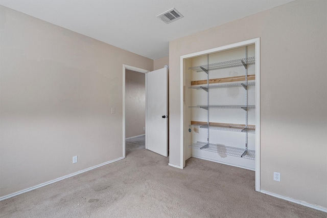 unfurnished bedroom with a closet and light carpet