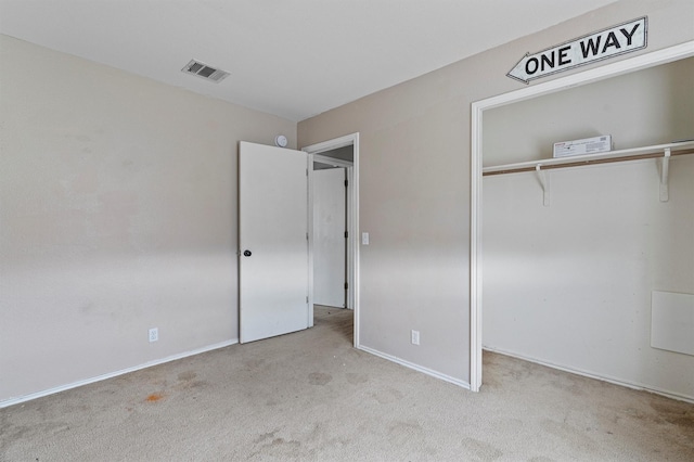 unfurnished bedroom with a closet and light carpet