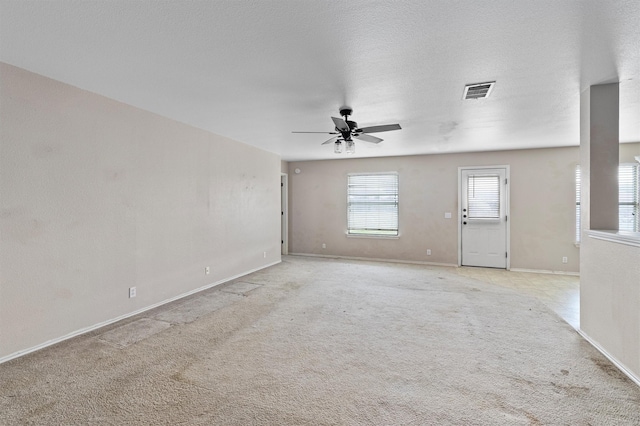 carpeted spare room with a textured ceiling and ceiling fan