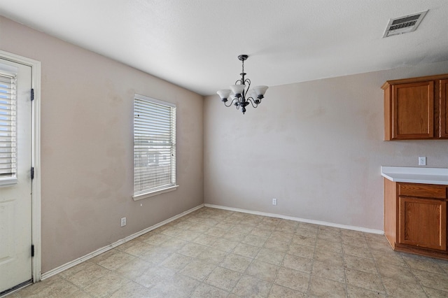 unfurnished dining area with a notable chandelier