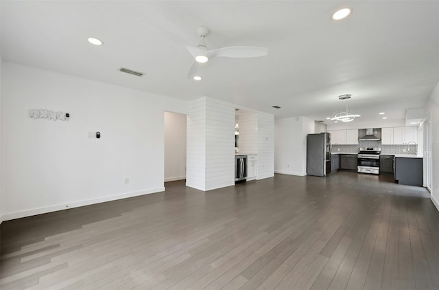 unfurnished living room featuring dark wood-type flooring, beverage cooler, ceiling fan, and sink