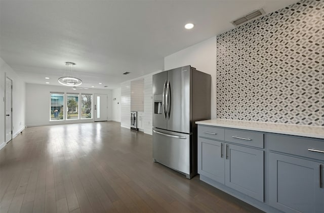 kitchen with gray cabinetry, stainless steel fridge with ice dispenser, and dark wood-type flooring