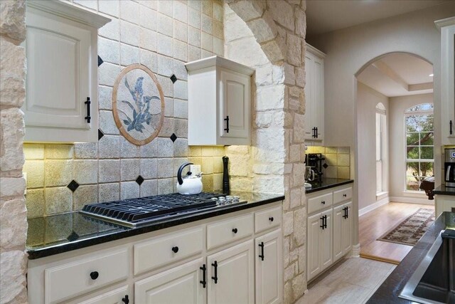 kitchen with light hardwood / wood-style flooring, decorative backsplash, and white cabinets