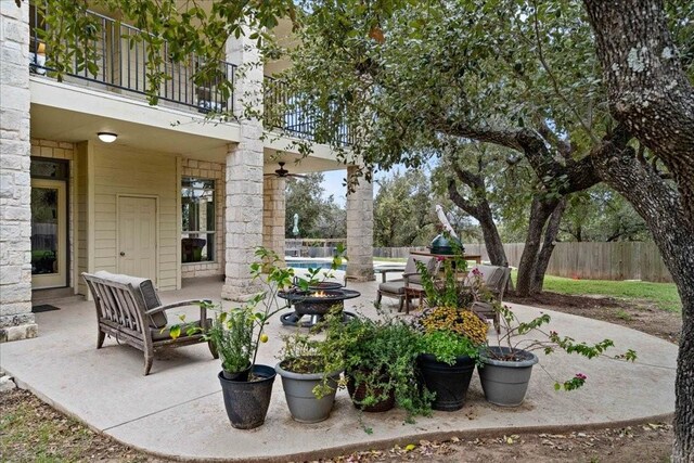 view of patio featuring a balcony and an outdoor fire pit