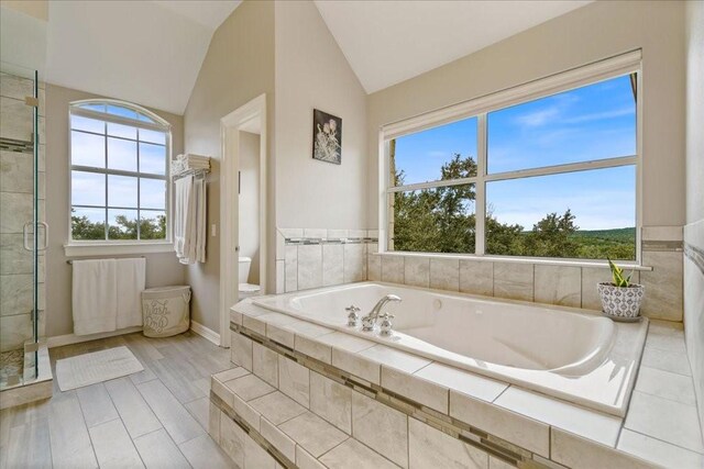 bathroom with independent shower and bath, lofted ceiling, and toilet