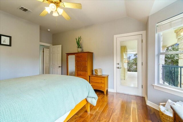 bedroom with ceiling fan, lofted ceiling, wood-type flooring, and multiple windows