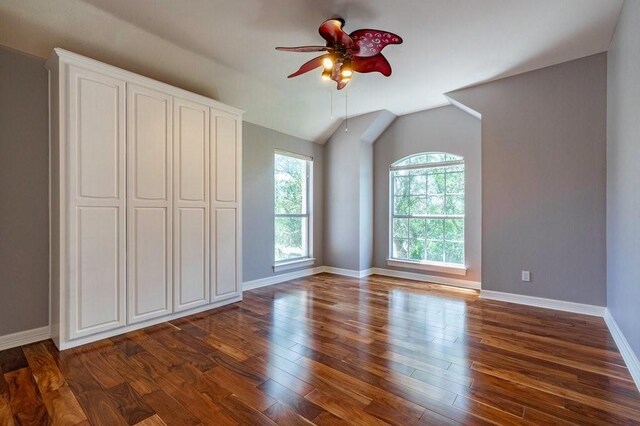 unfurnished bedroom featuring ceiling fan, dark hardwood / wood-style floors, and vaulted ceiling