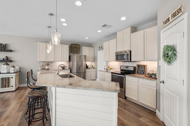 kitchen with hanging light fixtures, white cabinets, sink, and stainless steel appliances