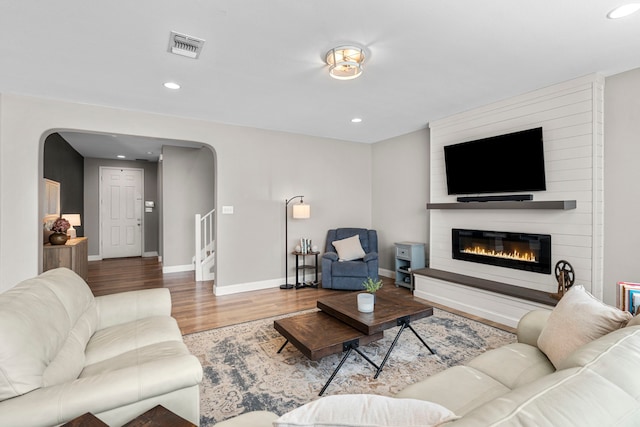 living room featuring wood-type flooring and a fireplace