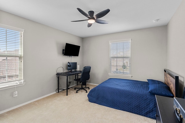 bedroom featuring light carpet, ceiling fan, and multiple windows