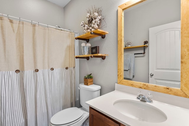 bathroom with toilet, vanity, and a shower with curtain