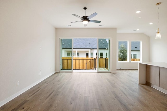 unfurnished living room featuring ceiling fan, lofted ceiling, and wood-type flooring