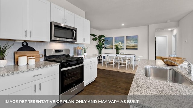 kitchen with stainless steel appliances, white cabinetry, tasteful backsplash, and sink