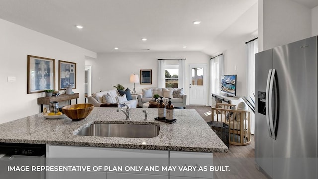 kitchen featuring sink, stainless steel appliances, light stone countertops, and hardwood / wood-style flooring