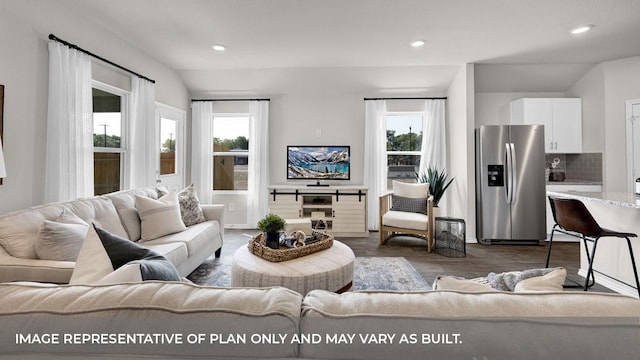 living room featuring vaulted ceiling, a wealth of natural light, and dark wood-type flooring