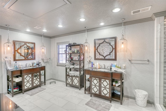 interior space featuring vanity, a textured ceiling, and ornamental molding