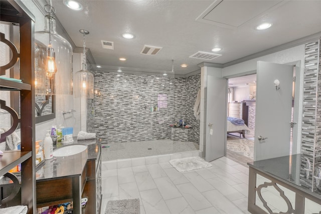 bathroom with tile walls, ornamental molding, tiled shower, and vanity