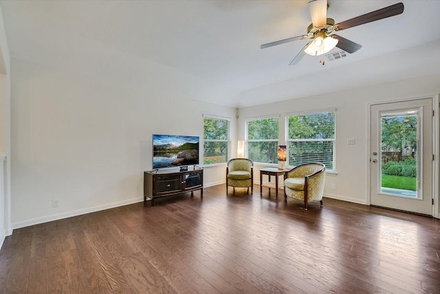 living area featuring dark wood-type flooring and ceiling fan