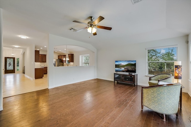 living room featuring ceiling fan with notable chandelier and dark hardwood / wood-style floors