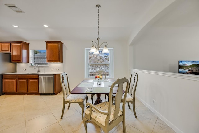 dining room featuring sink, light tile patterned floors, and a notable chandelier