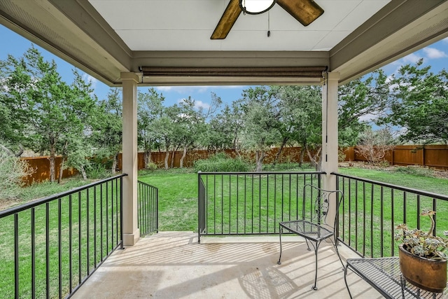 wooden terrace with ceiling fan and a yard