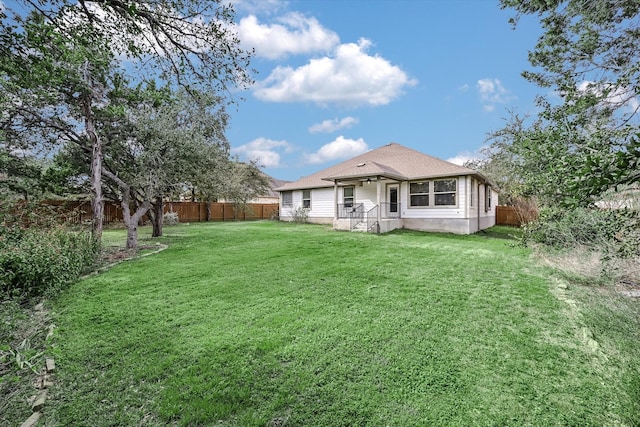 rear view of property with a yard