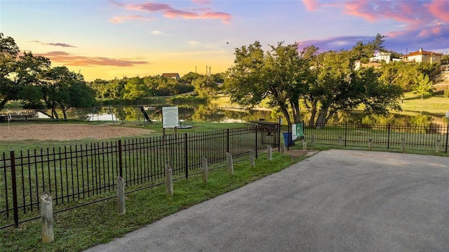 view of home's community with a lawn and a water view