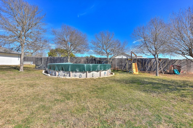 view of yard featuring a covered pool and a playground