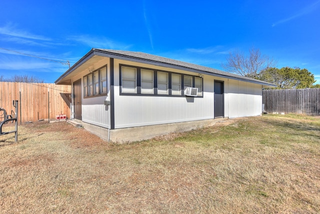 view of side of home featuring cooling unit and a lawn