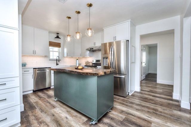 kitchen featuring white cabinets, appliances with stainless steel finishes, pendant lighting, and a center island