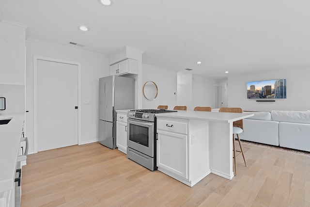 kitchen with stainless steel appliances, white cabinets, a breakfast bar, and crown molding