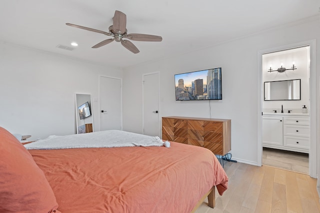 bedroom featuring ensuite bathroom, light wood-type flooring, ceiling fan, and sink