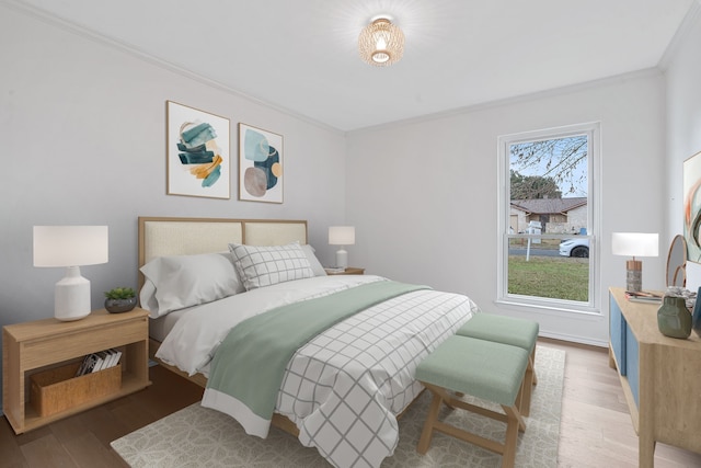 bedroom featuring multiple windows, ornamental molding, and hardwood / wood-style floors