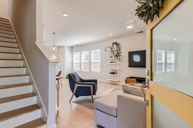 living room with ceiling fan and light hardwood / wood-style flooring